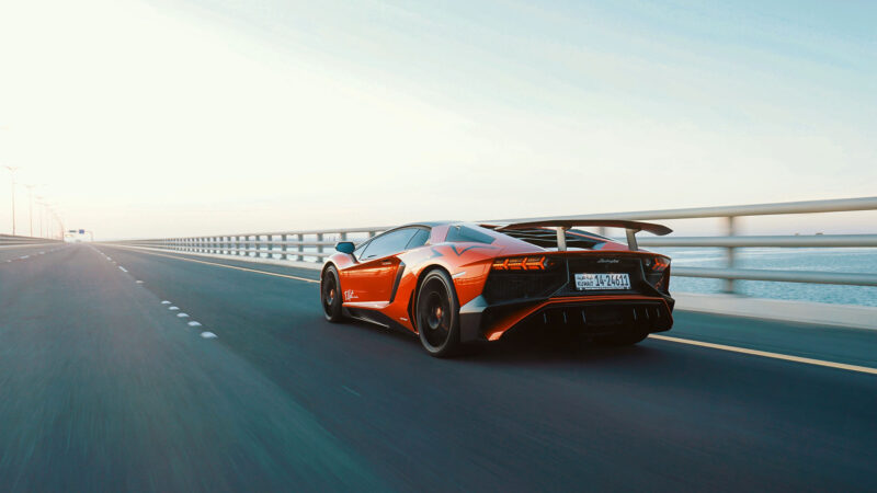 Lamborghini Aventador speeding down a highway bridge over water