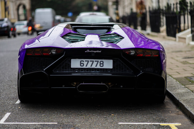 Purple Lamborghini Avenador parked on a European city street.