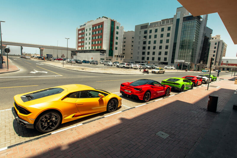 Yellow Huracan, Red Ferrari parked on a street