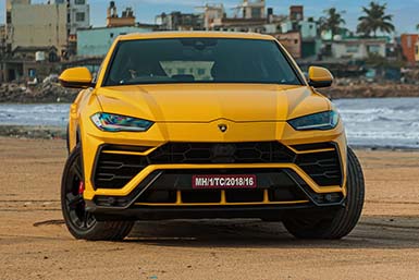 Lamborghini Urus in yellow at the beach.
