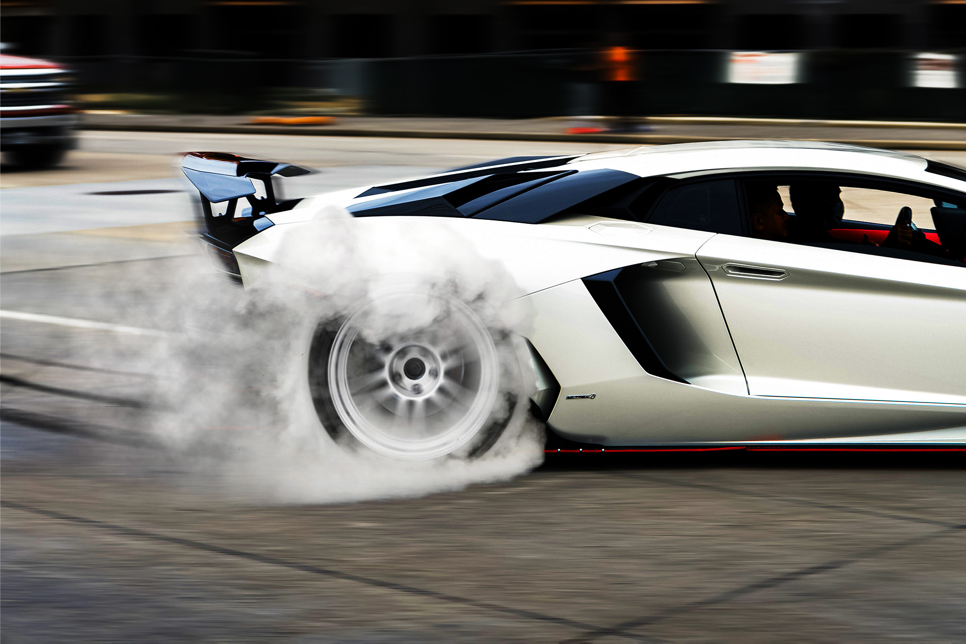 White Lamborghini Aventador doing a rear wheel drive burnout.