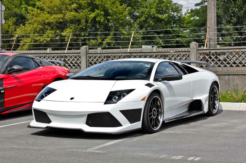 Lamborghini Murcielago parked in a parking lot at an exotic car show with custom rims.