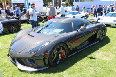 Koenigsegg Regera in natural carbon being displayed in at a car show on the grass.